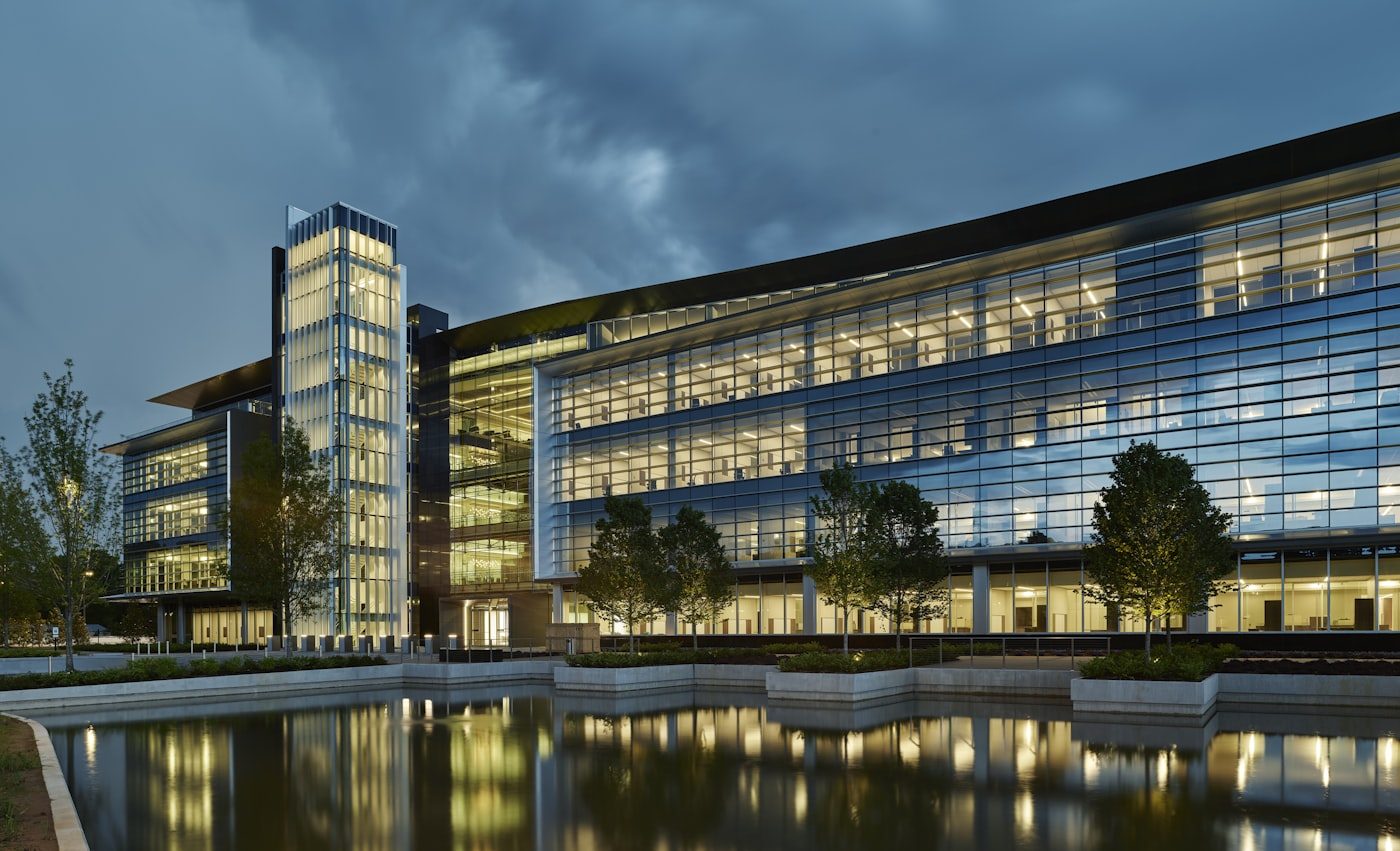 A modern glass office building beside water